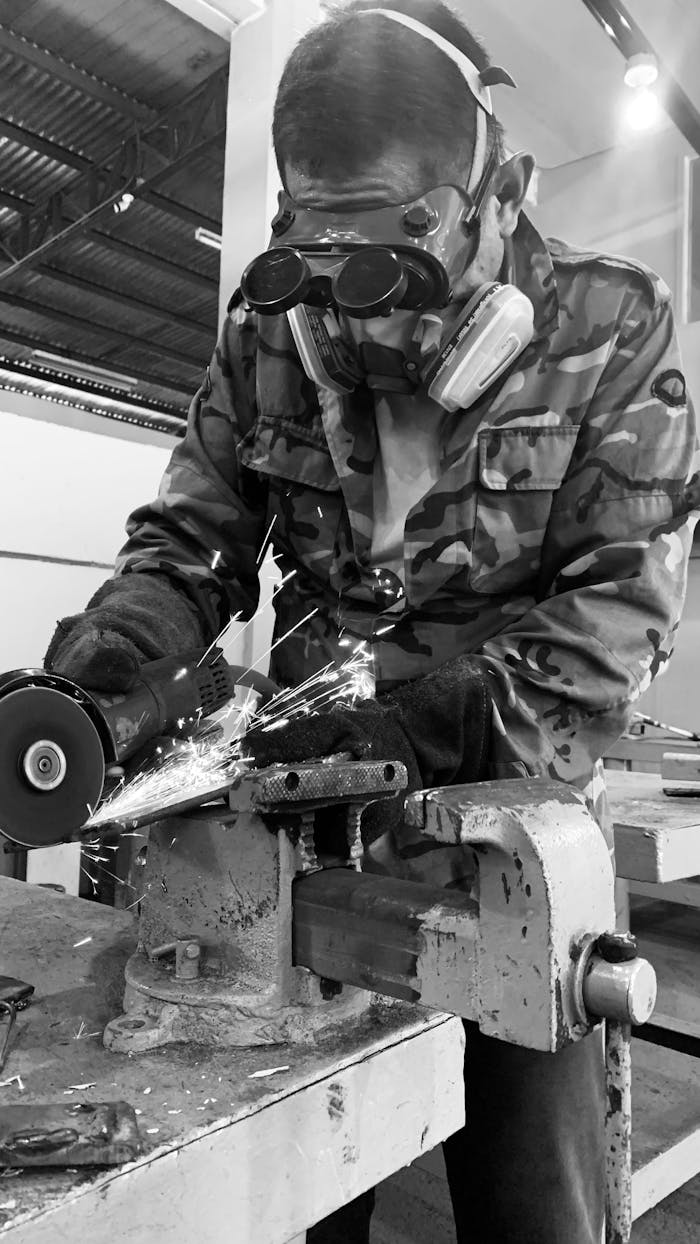 A welder using an angle grinder, showcasing sparks flying in a workshop environment.